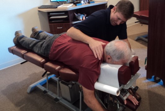 Dr. Chad and an older gentleman lying on the adjusting table